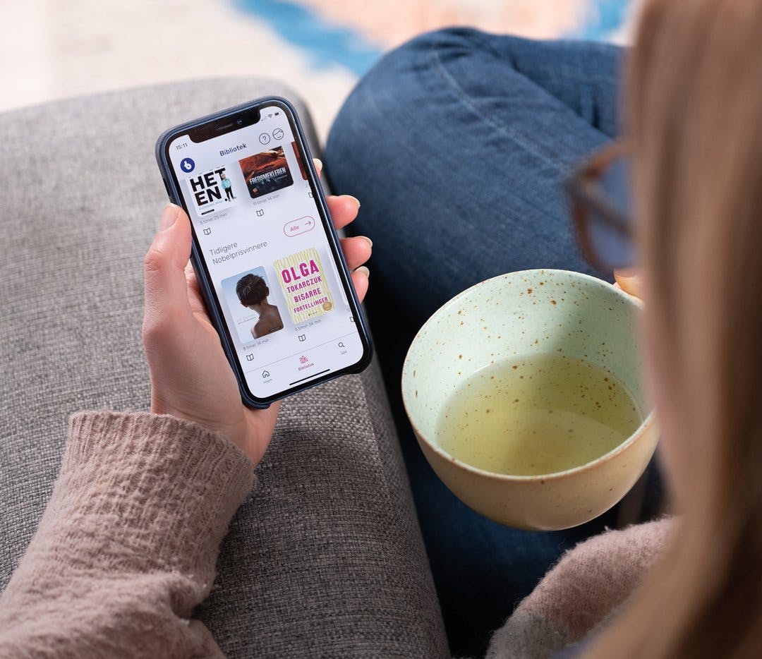 Kvinne drikker te og bruker BookBites-appen